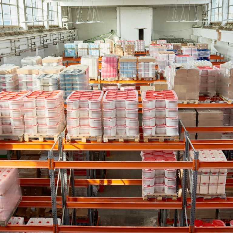High angle view at tall storage shelves with packed goods in warehouse, background with copy space